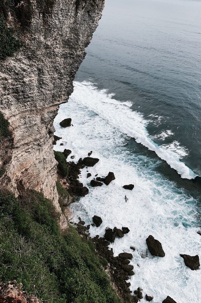 Waves breaking against the limestone cliffs of Uluwatu