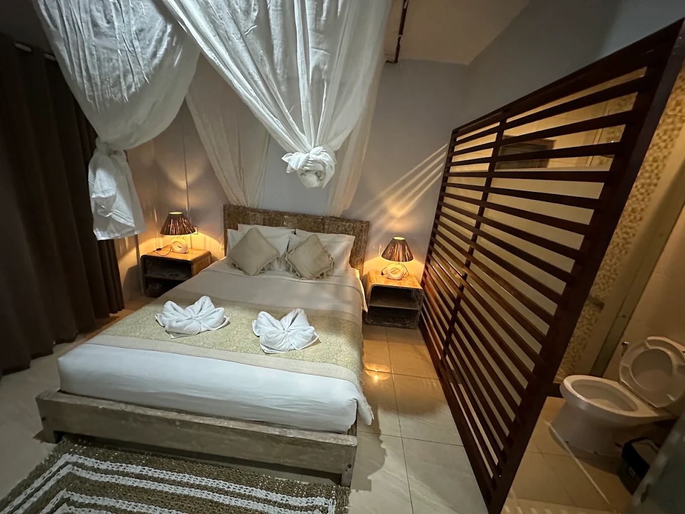 Bedroom with canopy bed and carved wooden screen