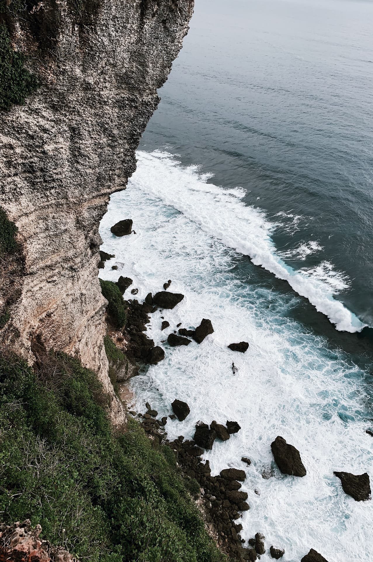 Waves breaking against the limestone cliffs of Uluwatu