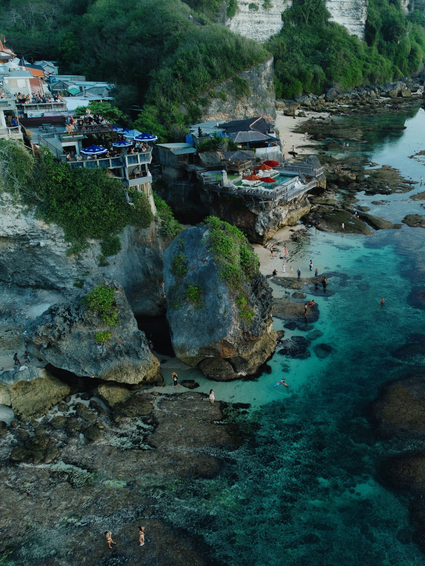 Aerial view of cliffside bars and pools above the turquoise water at Suluban, Uluwatu